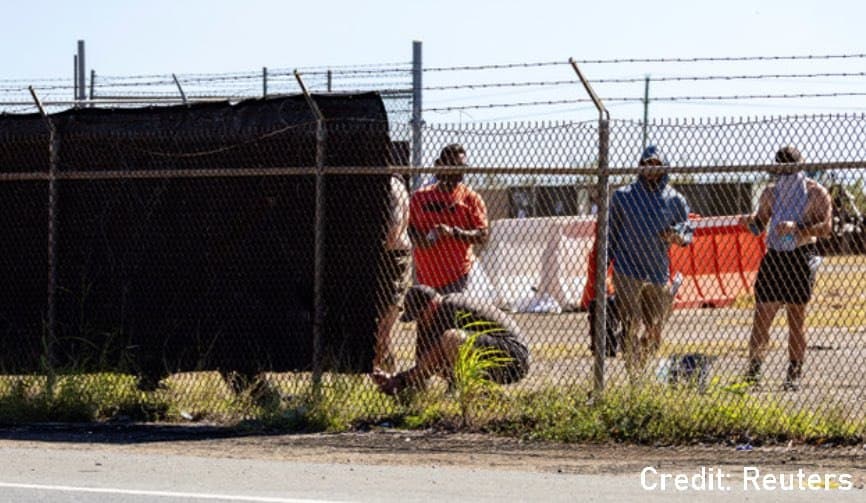 Personnel install covers on fence lines at Rafael Hernández Airport