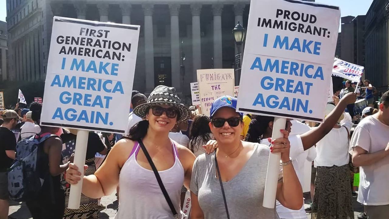 Protesters carry a dog crate with baby dolls inside